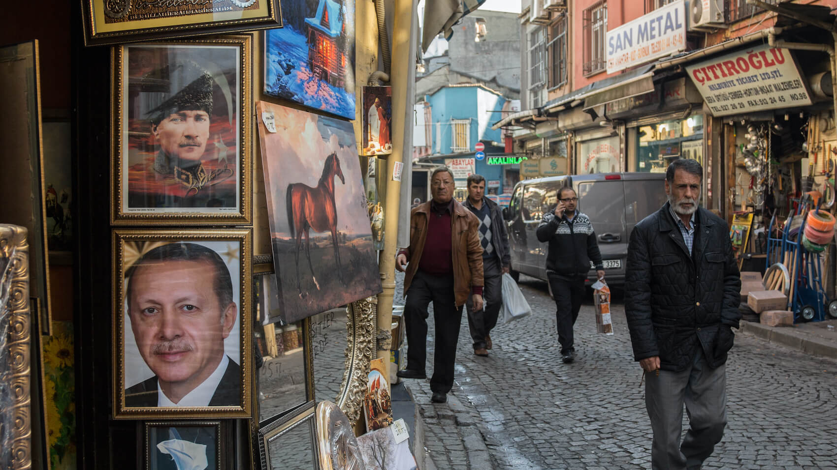 People passing by portraits of Mustafa Kemal Ataturk and Recep Tayyip Erdogan in Istanbul, Turkey on December 28, 2015.