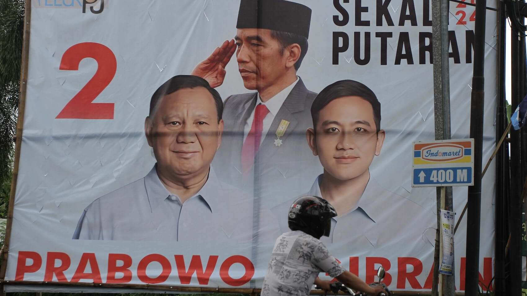 Motorcyclist passes the banner of Presidential Candidate Prabowo Subianto and his running mate Gibran Rakabuming Raka in Sleman, Yogyakarta, Indonesia on January 18, 2024. Photo: Angga Budhiyanto.