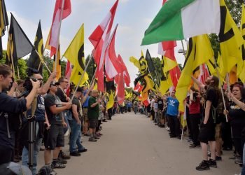 Demonstrators of the Austrian Identitarian movement form a guard of honor of flags in Vienna, Austria on June 11, 2016. Photo: Johanna Poetsch.