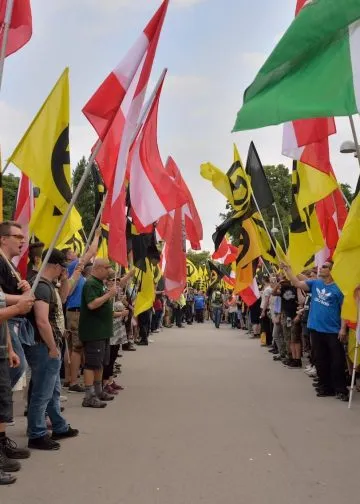Demonstrators of the Austrian Identitarian movement form a guard of honor of flags in Vienna, Austria on June 11, 2016. Photo: Johanna Poetsch.