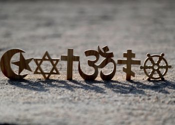 Religious symbols on sand: Christianity, Islam, Judaism, Orthodoxy Buddhism and Hinduism. Photo: Godong Photo.