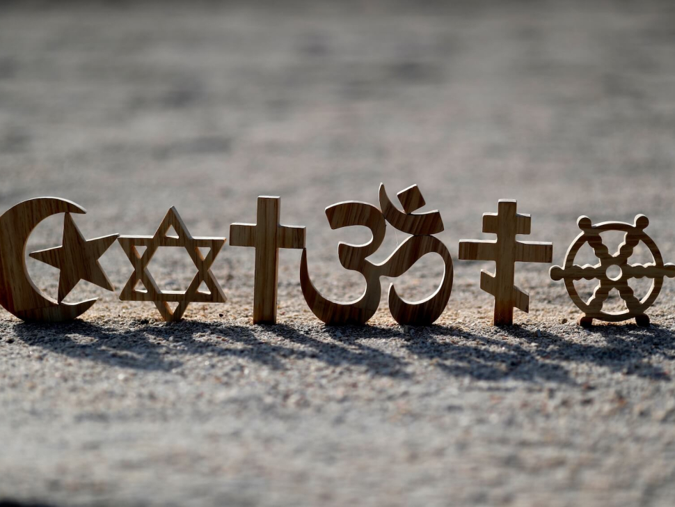 Religious symbols on sand: Christianity, Islam, Judaism, Orthodoxy Buddhism and Hinduism. Photo: Godong Photo.