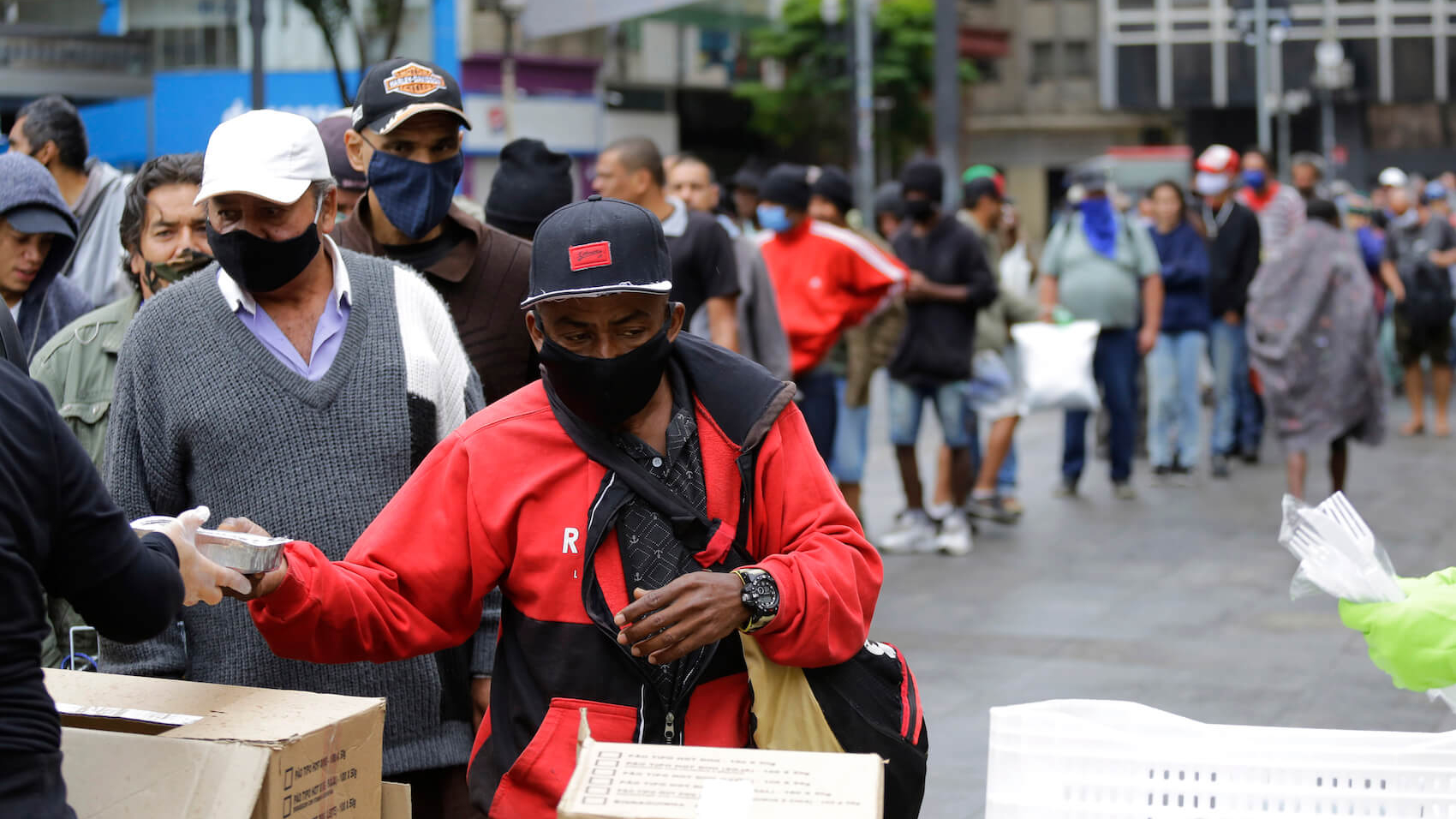 People wait in a long line to receive food donations for lunch on a downtown street in São Paulo, Brazil, during a severe economic crisis caused by the COVID-19 pandemic on June 2, 2020. Photo: Nelson Antoine.