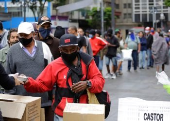 People wait in a long line to receive food donations for lunch on a downtown street in São Paulo, Brazil, during a severe economic crisis caused by the COVID-19 pandemic on June 2, 2020. Photo: Nelson Antoine.