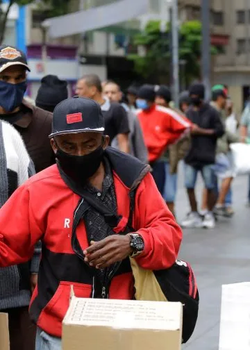 People wait in a long line to receive food donations for lunch on a downtown street in São Paulo, Brazil, during a severe economic crisis caused by the COVID-19 pandemic on June 2, 2020. Photo: Nelson Antoine.