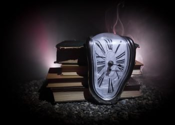 Distorted soft melting clock on the old books. Photo: Zef Art.