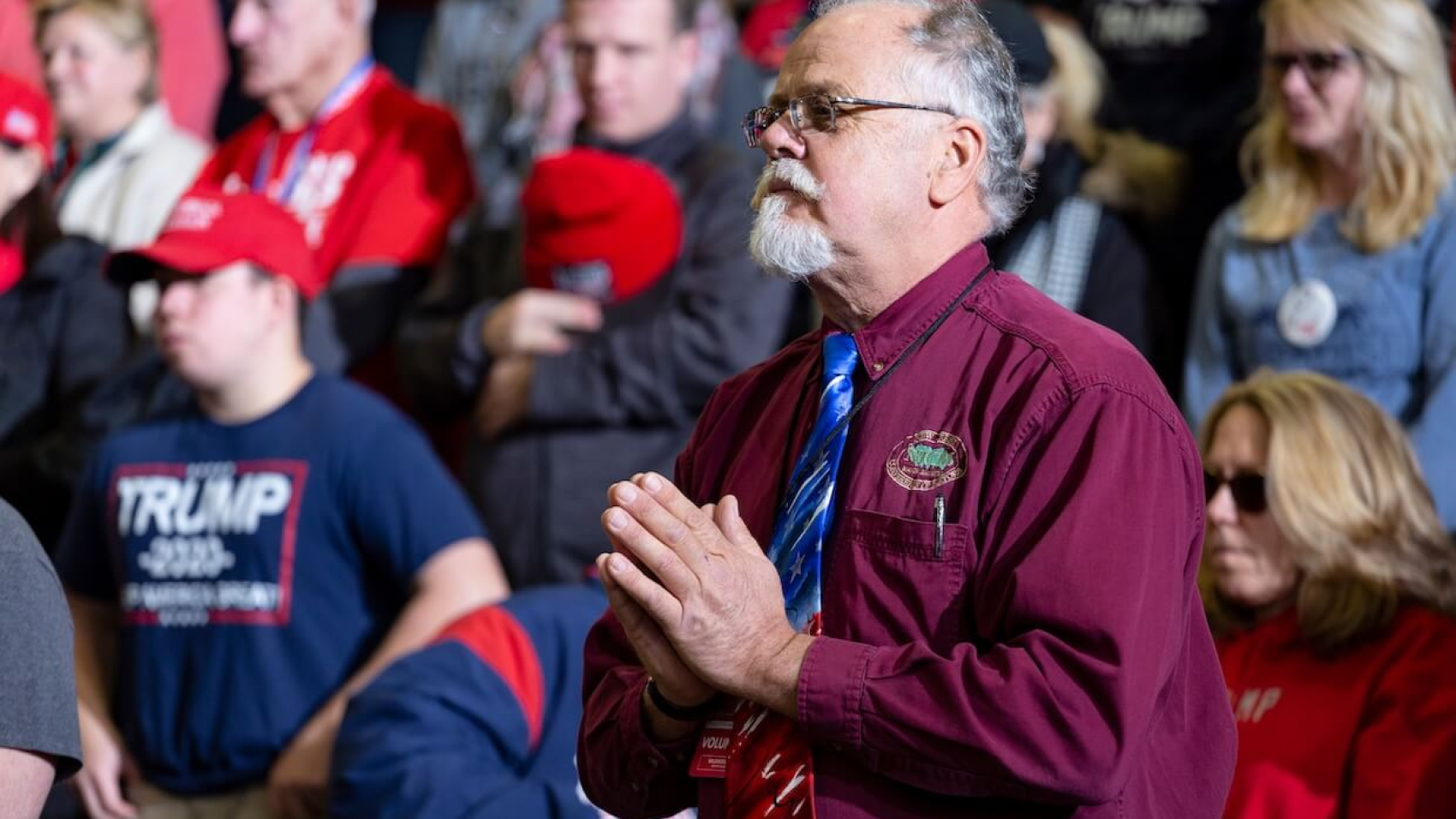 A man clasps his hands in prayer during the opening ceremonies of President Donald Trump’s "Keep America Great" rally at the Wildwoods Convention Center in Wildwood, New Jersey, on January 28, 2020. Photo by Benjamin Clapp.