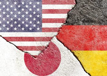 Faded USA vs Germany vs Japan national flags icon isolated on broken weathered cracked wall background, abstract US Germany Japan politics relationship divided conflicts concept texture wallpaper.