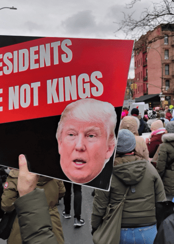 Demonstrators at The People’s March, an evolution of the Women’s March, NYC, January 18, 2025. A protester holds a sign reading “Presidents Are Not Kings.” Photo: Erin Alexis Randolph.