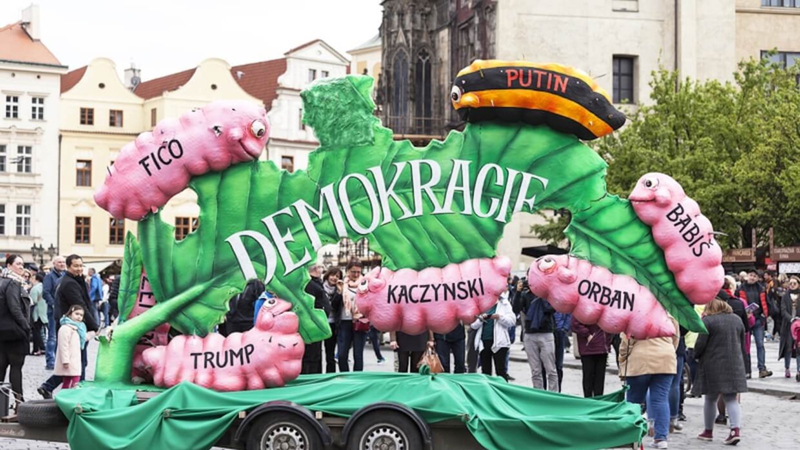 Labour Day celebrations at Old Town Square in Prague on May 1, 2017, featuring a banner depicting democracy as a leaf eaten by caterpillars labeled Putin, Kaczyński, Orbán, Babiš, Trump, and Fico.
Photo: Jolanta Wojcicka.