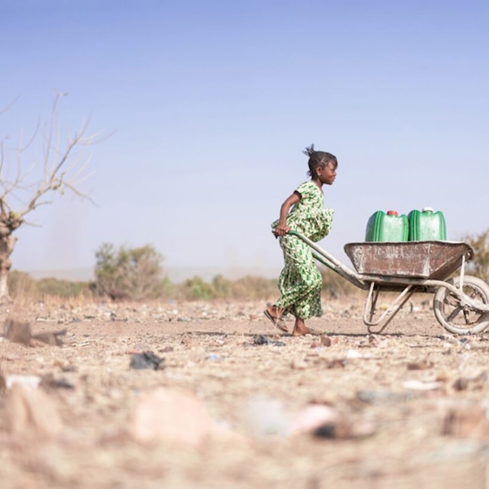 Young African woman carrying water.