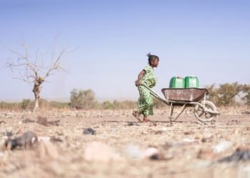 Young African woman carrying water.