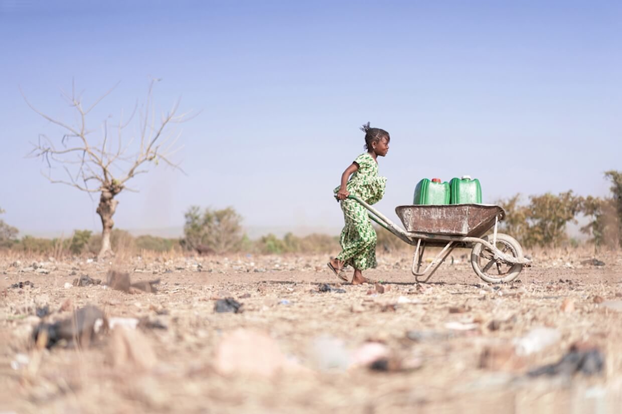 Young African woman carrying water.