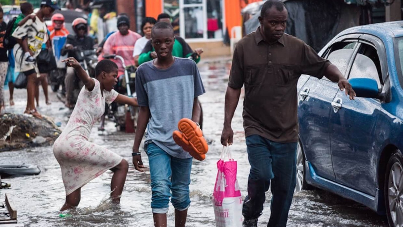 People walk along a flooded road after heavy rain in Lagos, Nigeria.