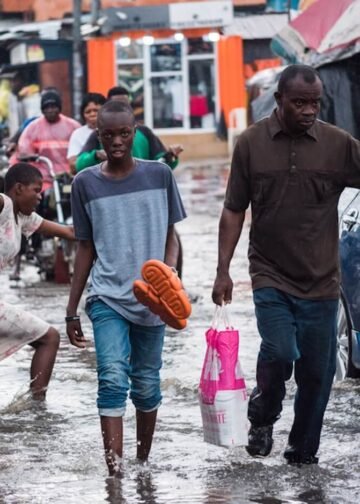 People walk along a flooded road after heavy rain in Lagos, Nigeria.