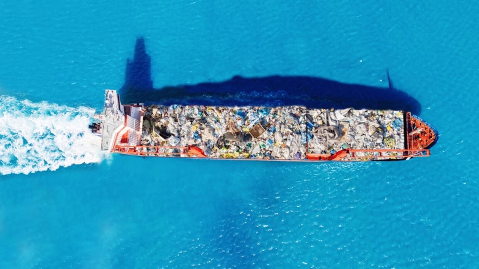 Cargo ship transporting containers of waste to a recycling facility. Conceptual image of global waste trade and environmental pollution. Photo: Evgeniy Parilov | Dreamstime.