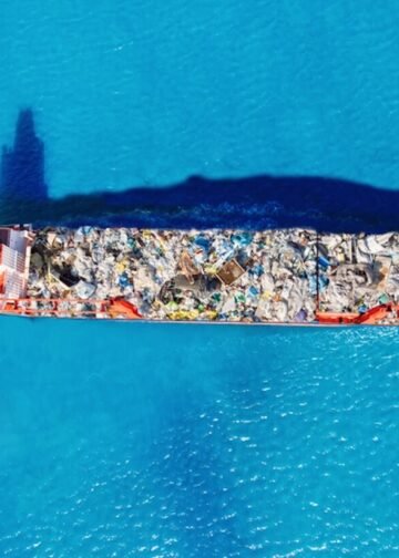 Cargo ship transporting containers of waste to a recycling facility. Conceptual image of global waste trade and environmental pollution. Photo: Evgeniy Parilov | Dreamstime.