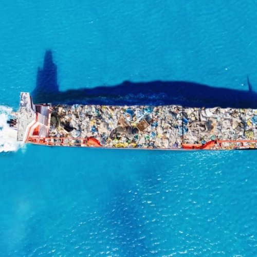 Cargo ship transporting containers of waste to a recycling facility. Conceptual image of global waste trade and environmental pollution. Photo: Evgeniy Parilov | Dreamstime.