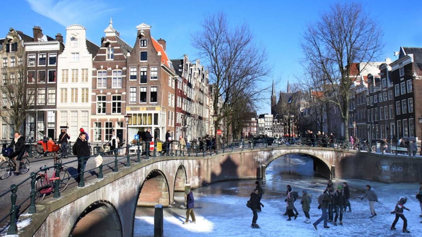 People skating on the frozen canals at the crossing of Leidsegracht and Keizersgracht in Amsterdam, the Netherlands. Amsterdam’s canals rarely freeze, allowing residents and visitors to walk and skate on the ice. Photo: Wessel Cirkel.