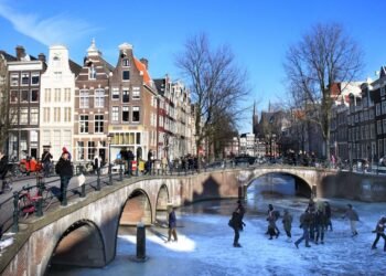 People skating on the frozen canals at the crossing of Leidsegracht and Keizersgracht in Amsterdam, the Netherlands. Amsterdam’s canals rarely freeze, allowing residents and visitors to walk and skate on the ice. Photo: Wessel Cirkel.
